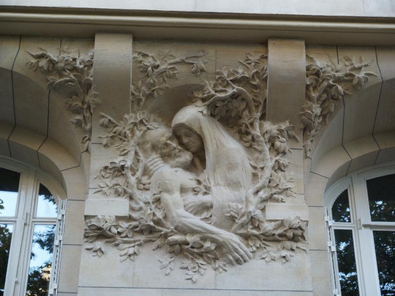 Paris, France: 276 Boulevard Raspail: wall sculpture of old woman holding old (dead?) man (1905, architect Theo Petit, sculpture E. Derre)