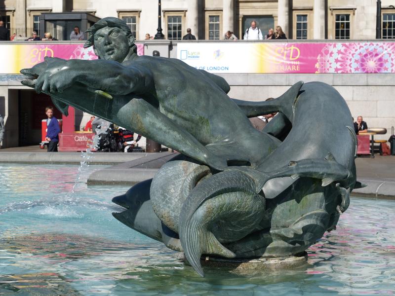 London, England: Trafalgar Square: east fountain merman and dolphins (1939, installed 1948, William McMillan)