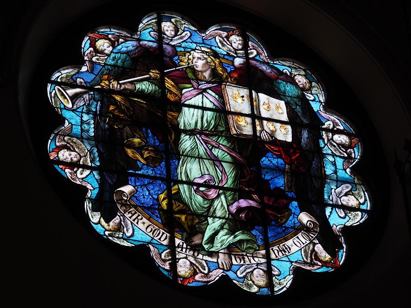 Utica, New York (NY): Grace Church: north rose window (angel with trumpet and book) (1886, Henry Holiday)