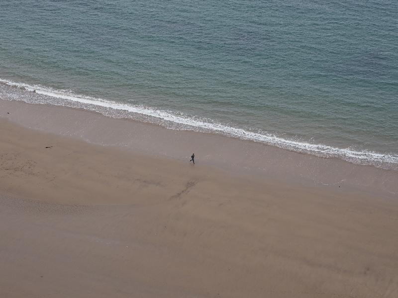 near Scarborough, England: Cleveland Way: jogger on beach