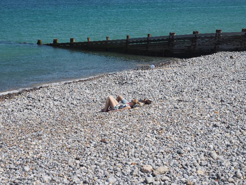 Cromer, England: beach: two people relaxing on rocky beach