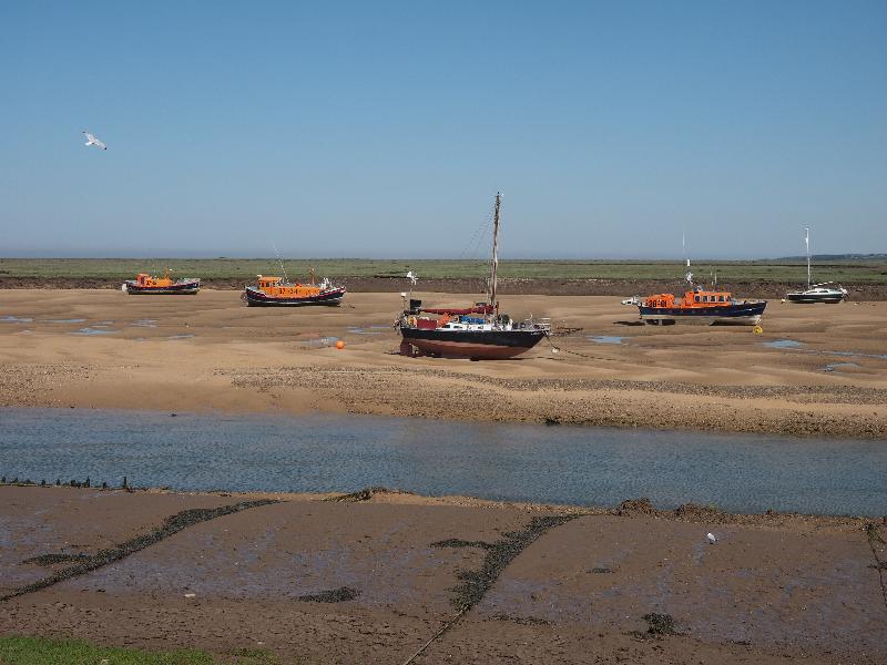 Wells-next-the-Sea, England: Beach Road: boats in inlet at low tide