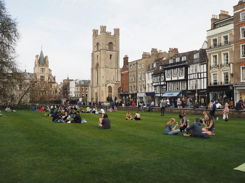 Cambridge, England: King's Parade: (mostly) socially distanced visitors sitting on King's front lawn
