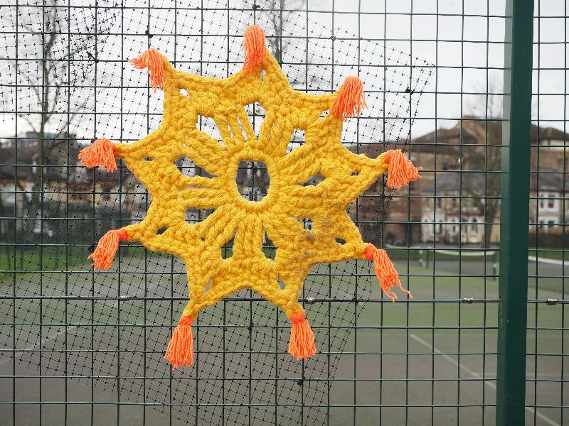 Cambridge, England: Jesus Green: yellow sun with orange tassels (Cambridge Yarn Collective)