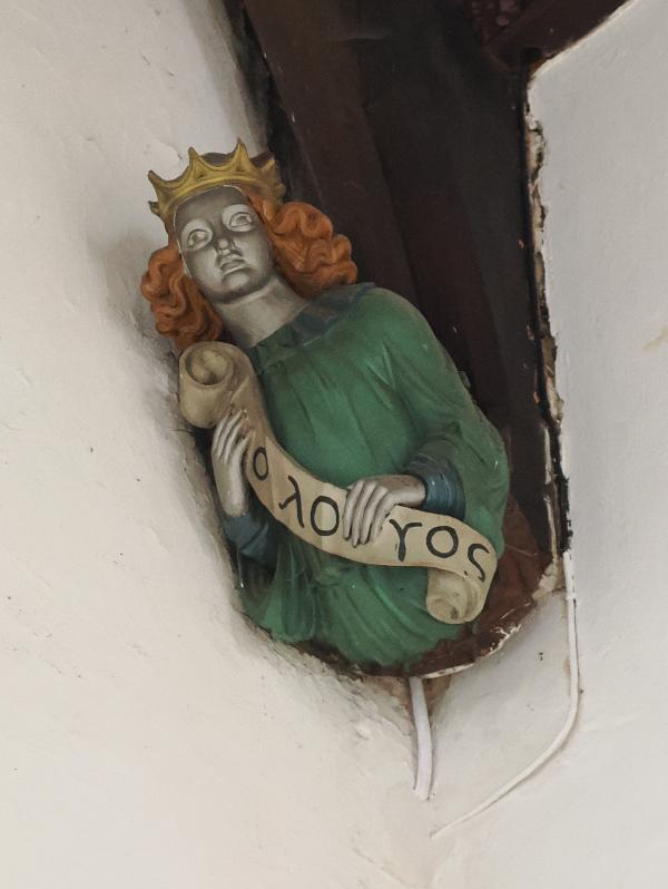 Cambridge, England: St Bene't's Church: south side of north aisle, figure with scroll text O LOGOS (The Word)