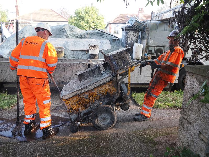 Cambridge, England: Roseford Road: workers carrying out Microsurfacing on pavement