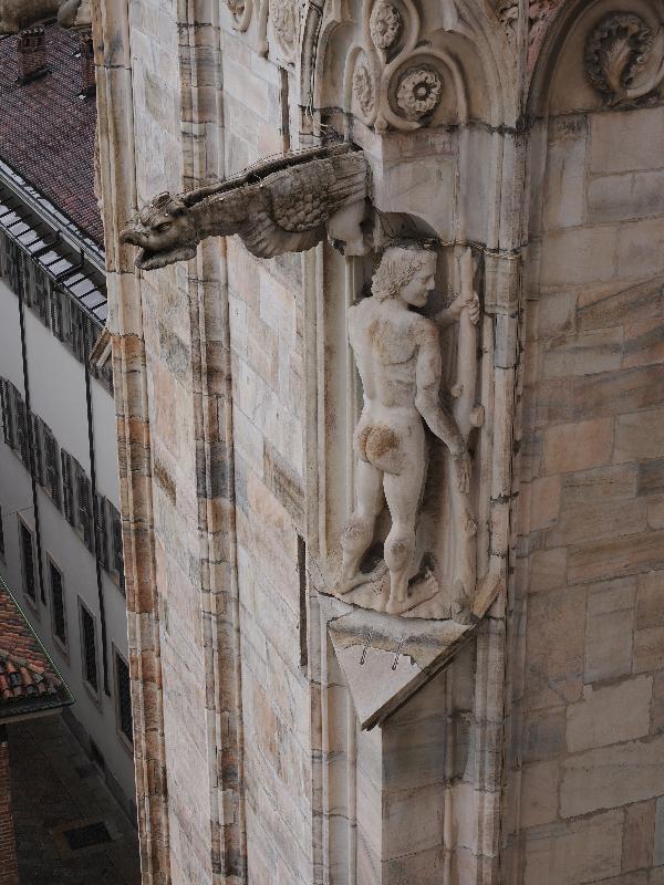 Milan, Italy: Duomo di Milano: gargoyle and naked man (Adam?) facing inwards