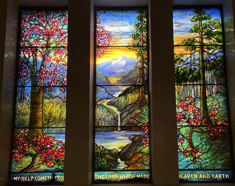 Murphy Memorial Window:  landscape with trees at left, conifers at right, mountains and water