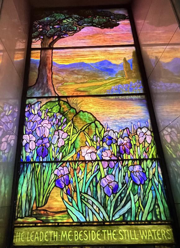 L.E. Block Memorial Window:  landscape with conifer at left, mountains, water and irises