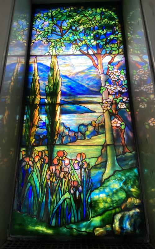 J. Burkhartsmeier Memorial Window:  landscape with two conifers at left, tree at right, irises