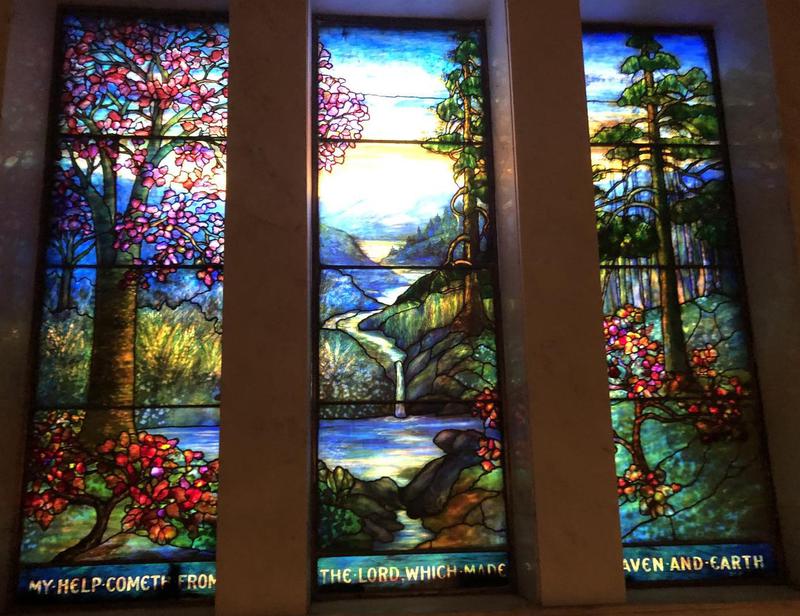 Murphy Memorial Window:  landscape with trees at left, conifers at right, mountains and water